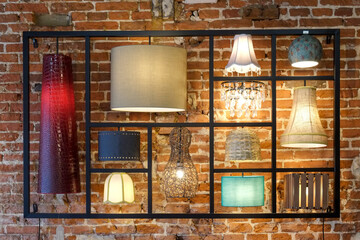Different style lamps on display against brick wall