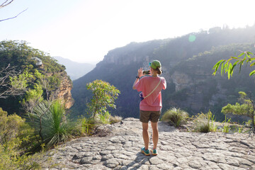 Rear view of woman photographing view of valley