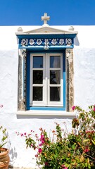 Fototapeta premium Ornate window with blue trim on whitewashed wall