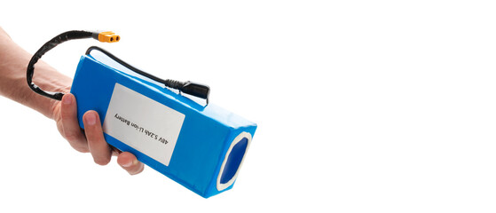 Hand holding battery from electric bicycle. Lithium-ion industrial high current batteries. With copy space, cut out.