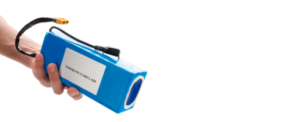 Hand holding battery from electric bicycle. Lithium-ion industrial high current batteries. With copy space, cut out.