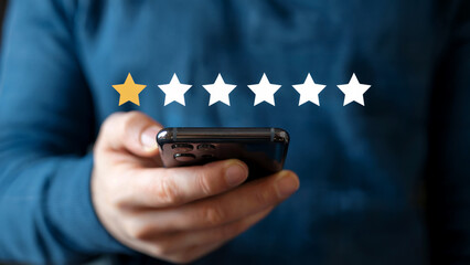 Disappointed customer rates service one star on smartphone screen, showing low satisfaction