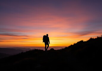 Silhouette of a Hiker Climbing a Hill at Sunrise with Dramatic Sky &ndash; Motivational and Inspirational Concept