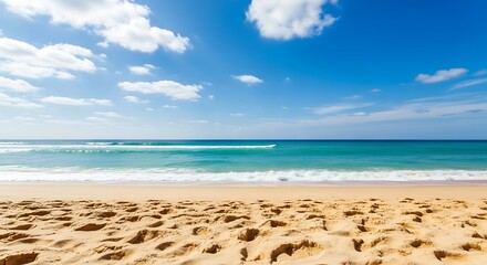 A beautiful sandy beach with gentle waves rolling onto the shore under a clear blue sky with fluffy white clouds, perfect for a relaxing vacation getaway