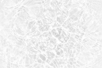 White water with ripples on the surface. Defocus blurred transparent white colored clear calm water surface texture with splashes and bubbles. Water waves with shining pattern texture background.