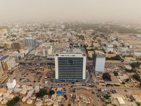 Aerial view of a sprawling city with a modern high-rise building standing tall amidst the low-rise structures, Nouakchott, Ksar, Mauritania.