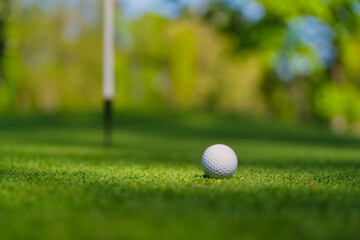 Golf ball and directions for hitting. Sports and hobbies. Sports competitions and active recreation. Individual and team game. Golf ball on a blurred background.