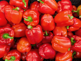 Raw red bell peppers on a vegetable market, top view