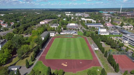 sports facilities at Hennigsdorf high school, including a soccer field, running track and other buildings in residential areas. Nice aerial view flight panorama overview drone