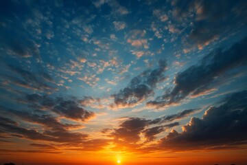 Fototapeta premium Vibrant orange and blue hues paint the clouds at sunset, creating a dramatic and beautiful sky