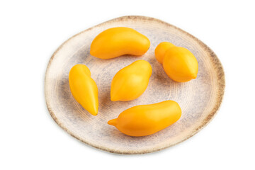 Yellow tomatoes on plate isolated on white. Side view, close up