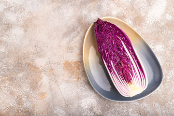 Purple Chinese cabbage on brown concrete background, top view, copy space