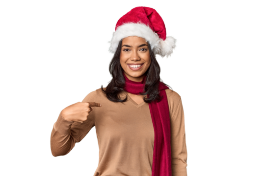 Filipino in Christmas attire and Santa hat person pointing by hand to a shirt copy space, proud and confident - Powered by Adobe