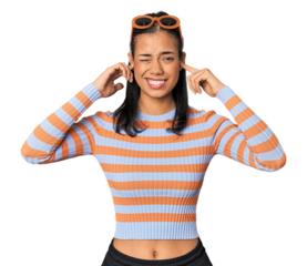 Young Filipino woman in studio covering ears with fingers, stressed and desperate by a loudly ambient.