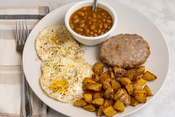 eggs over easy  with sausage patty and  home fries