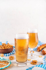Oktoberfest holiday background with beer glasses, salted snack and pretzels