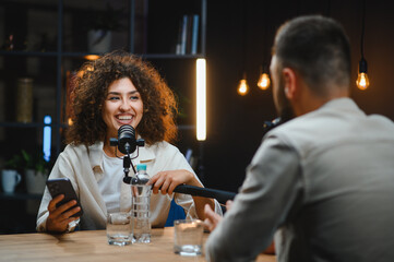 Two content creators recording podcast in modern studio