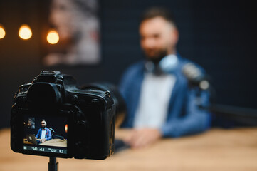 Video blogger recording content with professional camera in studio