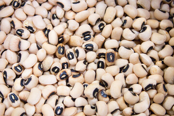 A full-frame shot of many raw black-eyed peas, a variety of cowpea bean