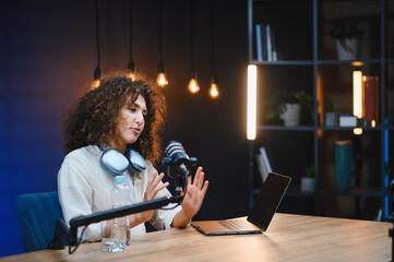 Young woman vlogger recording video podcast in home studio
