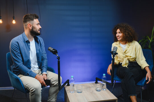 Podcasters discussing during recording session in modern studio