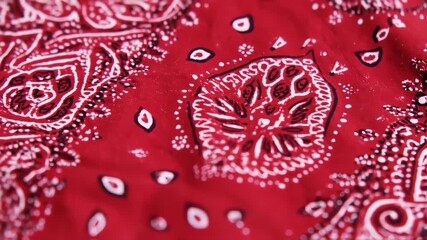 Close-up of a red bandana with intricate white and black paisley patterns
