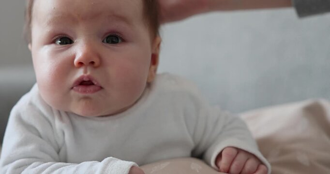 Neugieriges Baby liegt l&auml;chelnd auf dem Bauch