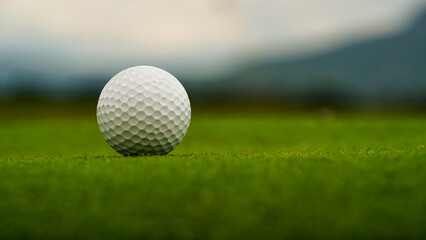 Golf clubs and balls on a green lawn in a beautiful golf course with morning sunshine.