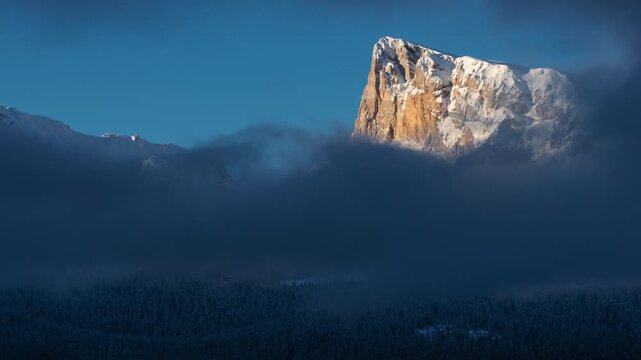 Time-lapse of winter clouds drifting in front of Pic de Bure in the Devoluy Massif. Snow-covered limestone cliffs and alpine scenery in Hautes-Alpes, French Alps, France