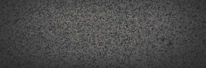 Dark gray granite texture. Natural granite with a grainy pattern. Solid rough surface of rock with spots, noise and grain. Dark stone background for design. Shaded texture with vignette.