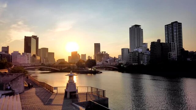 【タイムラプス】夕暮れ時の大阪天満橋から望む、中之島公園と川辺の景色