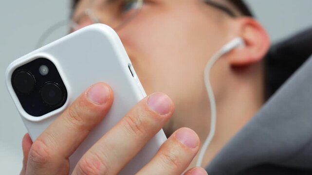 Close-up of white headphones in a person's hands.
Accessories for a smartphone.
Listening to music through headphones.
Modern mobile devices and accessories