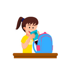 A little girl puts a book into her school bag
