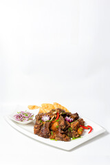 baked meat with onion rings and chili pepper. Meat set on a white background
