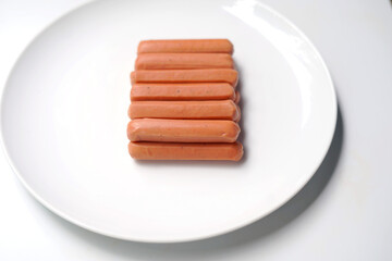 Fresh Meat Sausages on White Plate Surface.
