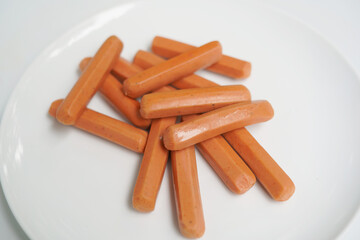 Uncooked Sausages on a White Plate.