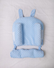 a blue baby pillow. A comfortable pillow for newborns on the bed