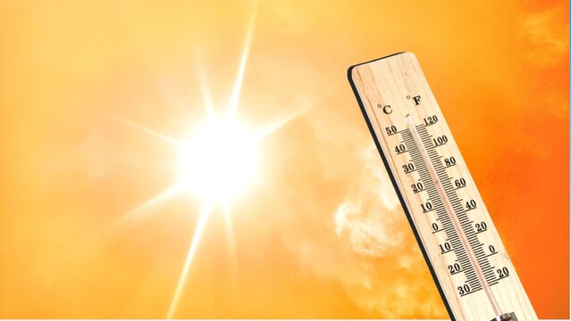 Thermometer with high temperature against orange sky background and shining sun. Heat wave concept. Extreme weather. Global warming effects