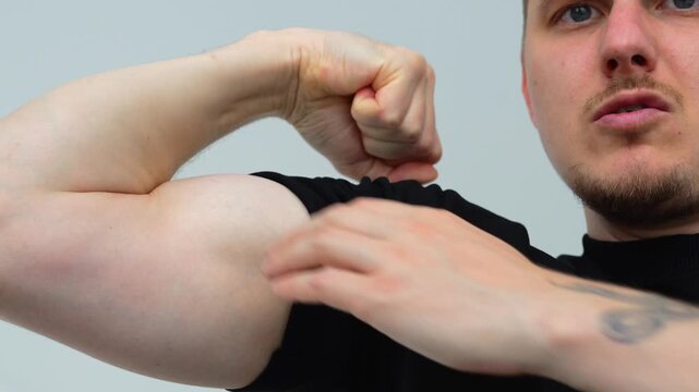 A man flexes his biceps and shows off his strength.
A pumped-up man shows off his pumped-up muscles in the gym after a workout.
A guy with a muscular arm