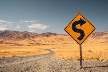 Yellow winding road sign in desert