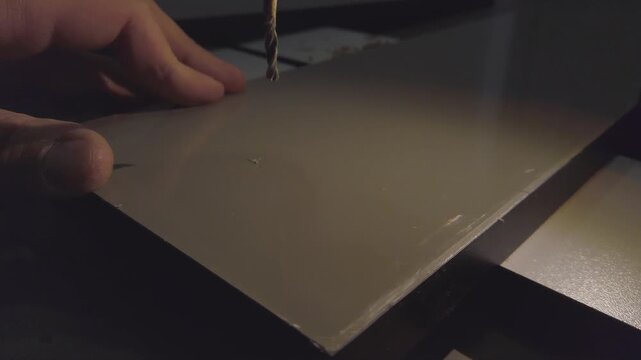 Hand drill making hole in an mdf board. DIY home project. Slow motion video