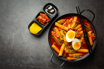Cheesy Tokbokki korean traditional food on black board background. Lunch dish.