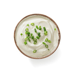 Sour cream or yogurt in white bowl isolated on white background. Thick sour cream with green chopped onions. Top view.