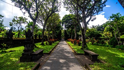 Fototapeta premium Lush tropical garden path lined with ancient statues