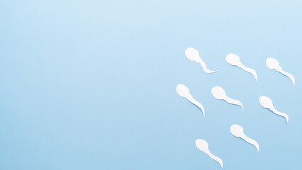 Sperm cells competition on blue background. Concept of fertilization, birth, male reproductive and sperm test. © Orawan