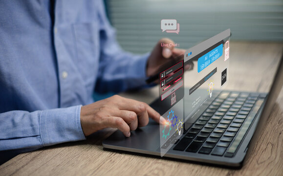 Businessman using laptop with hologram live chat interface and AI chatbot technology digital communication,Concepts of customer service