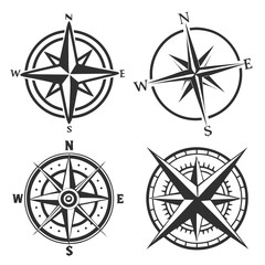 Obraz premium A collection of four distinct black and white compass rose designs each representing cardinal directions and offering a classic navigational symbol