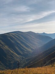 Serene mountain landscape with golden sunlight illuminating the rolling hills and deep valleys