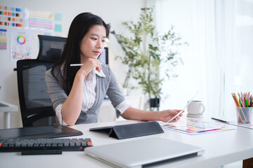 Female designer examining printed color samples in a modern office.