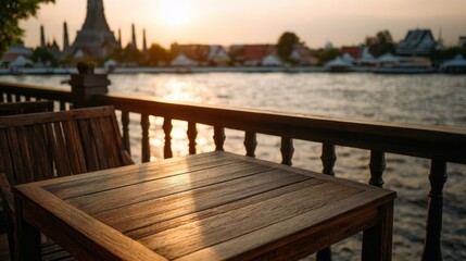 Wooden table balcony view of Wat Arun temple by Chao Phraya River at sunset Bangkok
